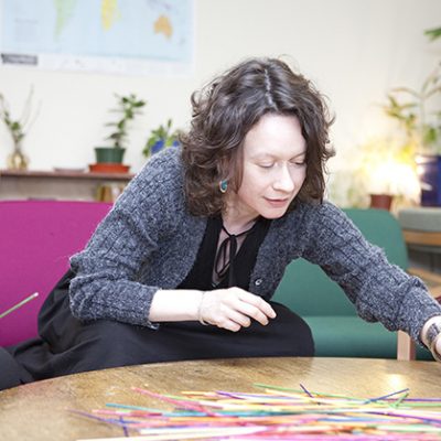 A woman is picking among items on a table