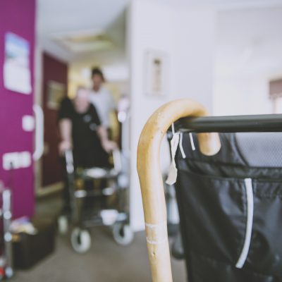 Walking stick hung on wheelchair