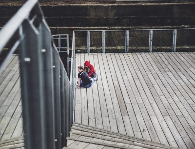 Two young girls sat looking at a river