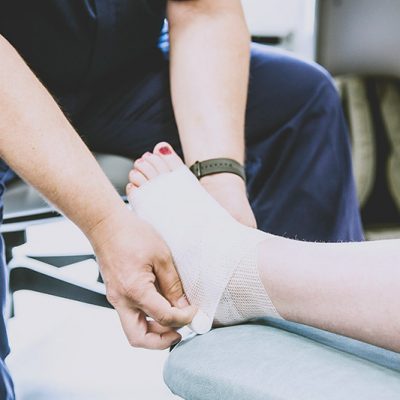 Nurse wrapping foot in bandage in Urgent Care Centre