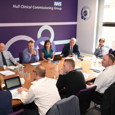 Board meeting with board members sat around a table at Wilberforce Court