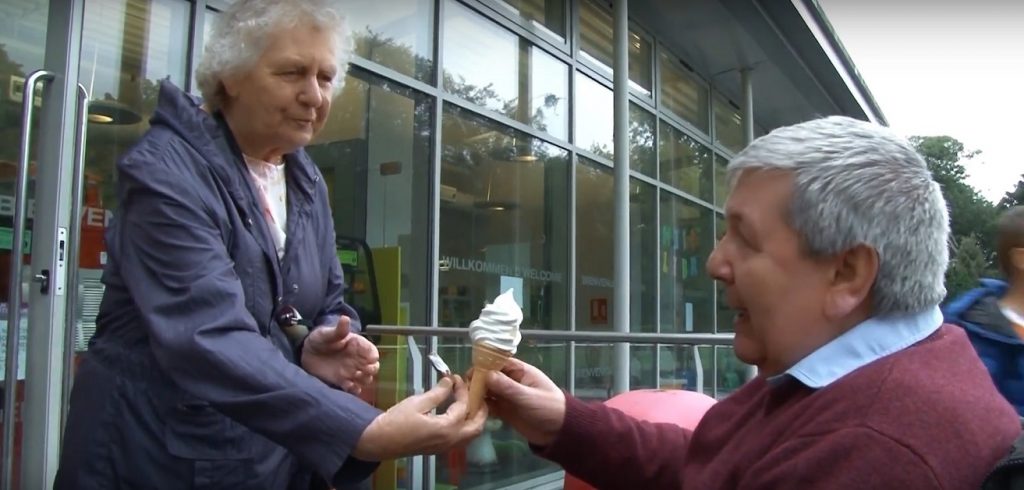 Old woman giving old man an ice cream