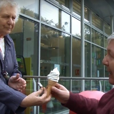 Old woman giving old man an ice cream