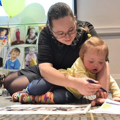 A woman is helping her daughter draw a picture