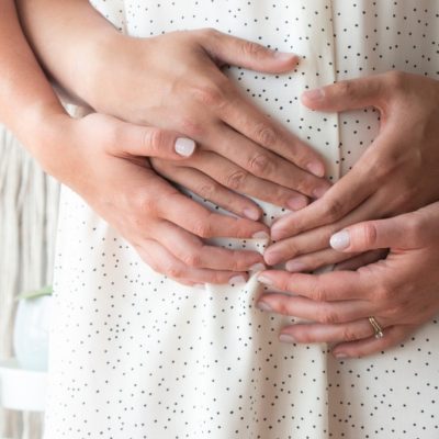 4 Hands on a pregnant woman's belly