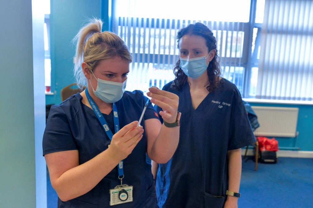 doctor and a nurse preparing to give vaccine